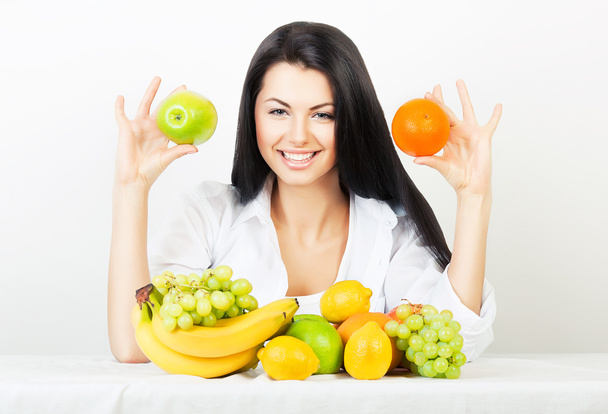 Mujer con manzana y naranja en las manos
 - Foto, Imagen
