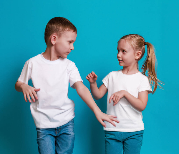 Mocap, caucasian boy and girl dancing in white t-shirts on a blue background - Valokuva, kuva