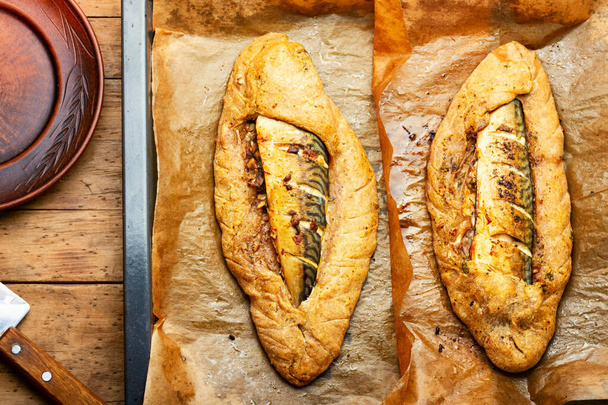 Mackerel baked in dough. Fish baked in bread loaf on baking sheet - Valokuva, kuva