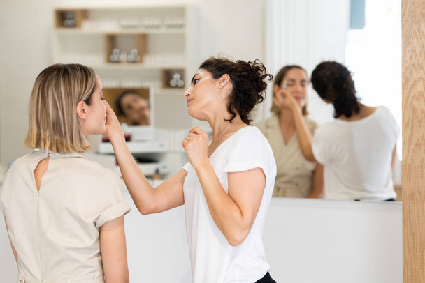 Cosmetoloog doet beauty procedure op het gezicht van de klant - Foto, afbeelding