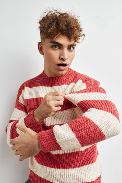 kinky guy in a striped sweater posing light background - Zdjęcie, obraz