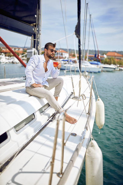 Casual charming man sailing alone on the yacht - Photo, Image