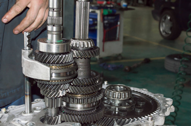 Side view of shafts and gears of a partially disassembled mechanical transmission in an auto repair shop - Photo, Image