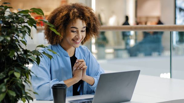 アフリカ系アメリカ人の女の子学生ビジネス女性のユーザーの勝者は、ラップトップを入力して驚きはいジェスチャーはい喜び良いニュース幸福勝利機会新しいジョブ通知コンピュータゲーム勝利 - 写真・画像