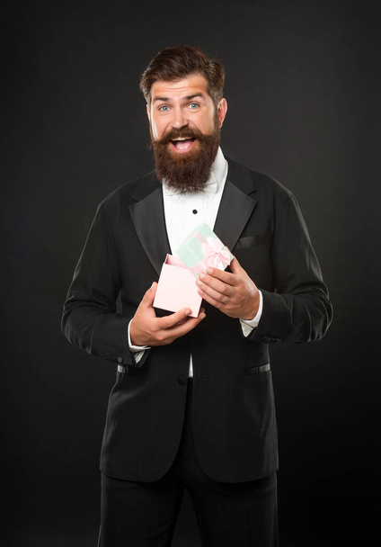 happy man in tuxedo bow tie formalwear on black background open box. shopping sale - Фото, изображение