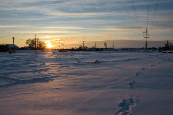Winter zonsondergang boven een besneeuwde glade aan de rand van de stad. Goedenavond en niemand. - Foto, afbeelding
