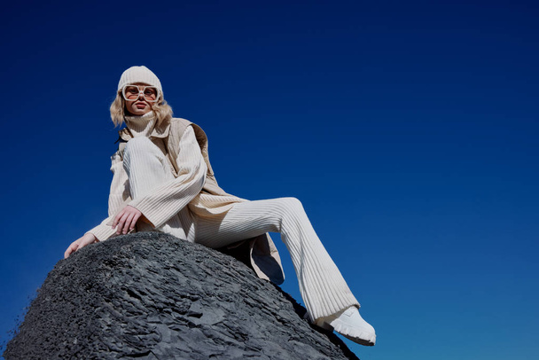mujer en la ropa de otoño se encuentra en un paisaje de roca azul cielo estilo de vida - Foto, Imagen