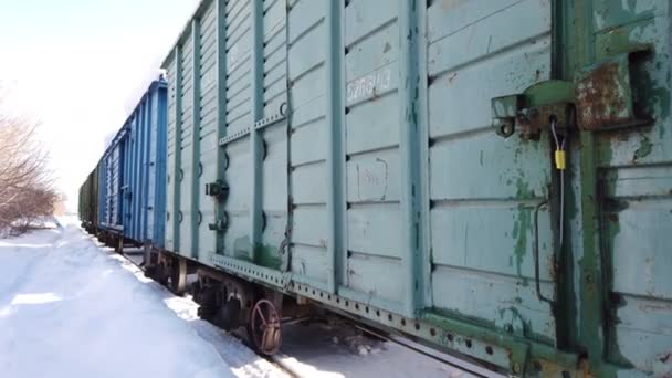 Carri merci in legno di treno merci alla stazione ferroviaria in inverno. Treni merci in stile sovietico. - Filmati, video