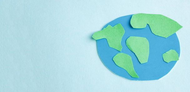 Aplicação de papel de crianças bonito - um modelo da Terra em um fundo azul. Conceito criativo Dia da Terra, Hora da Terra, espaço de cópia para texto. - Foto, Imagem