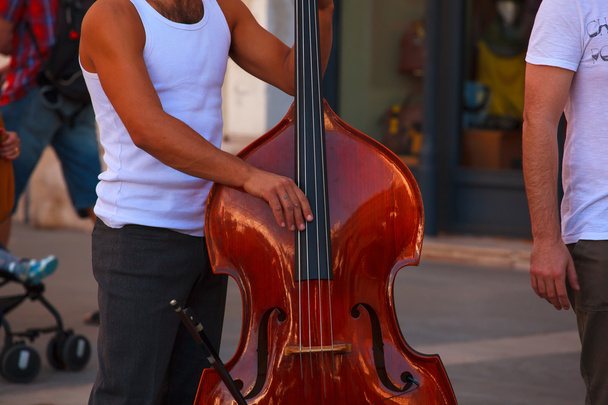 Уличный музыкант играет на контрабасе
 - Фото, изображение