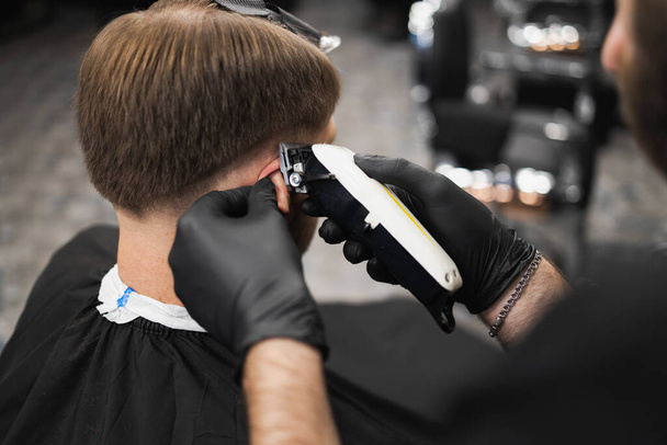Haircut and styling in barbershop. Man in barbershop - Foto, afbeelding