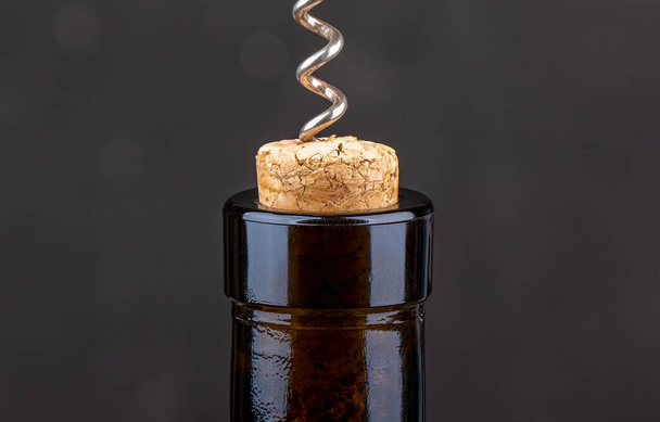 Closeup of a corkscrew inside a wine cork in a bottle. - Fotó, kép