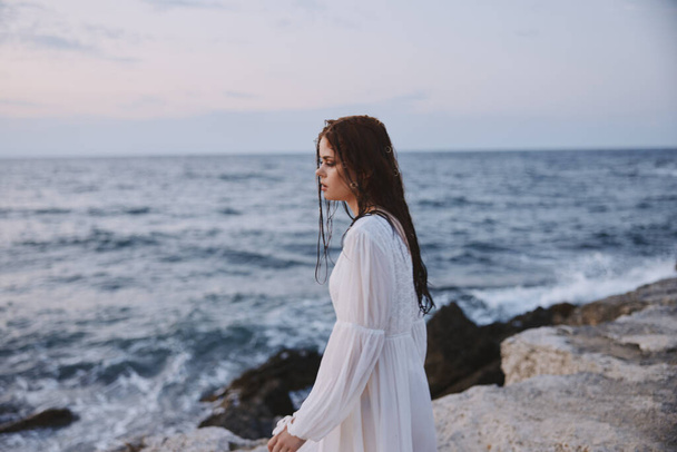 mujer mirando a la distancia de pie en las rocas paisaje océano viaje - Foto, imagen