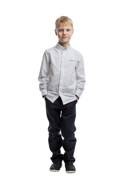 The boy is standing. A guy in a white shirt and dark trousers. Full height. Isolated on white background. Vertical. - Фото, зображення