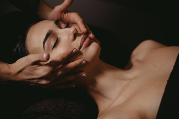 Beautiful girl has a facial massage in a beauty clinic. - Φωτογραφία, εικόνα