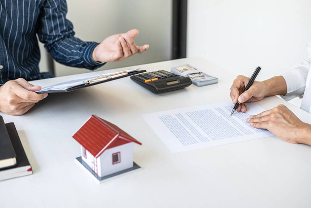 Real estate broker agent consult to customer to decision making sign insurance form and sending house model to client after approve, home model mortgage loan offer for and house insurance. - Foto, afbeelding