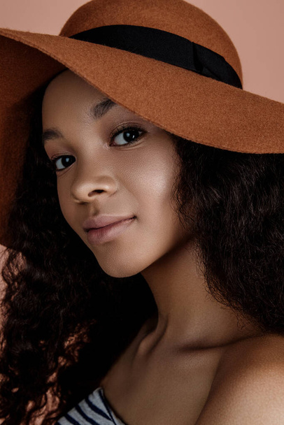 Şapkalı şehvetli genç bir kadının portresi. Temiz cilt. Sağlıklı bakım. Şapkalı güzel bir Afrikalı Amerikalının portresi. Stüdyo çekimi. Doğal çıplak makyajlı güzellik modeli portresi. - Fotoğraf, Görsel