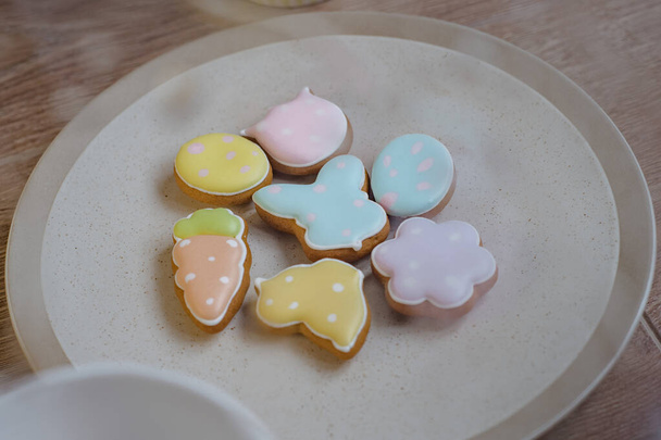 Gingerbread Cookies in shape of eggs and Easter bunny. Easter background with spring flowers. - Photo, Image