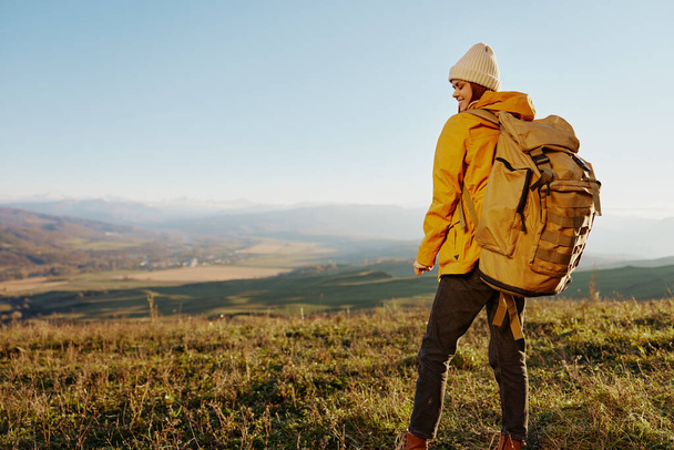 nainen matkustava keltainen takki hattu reppu matkustaa vuoret raitista ilmaa - Valokuva, kuva