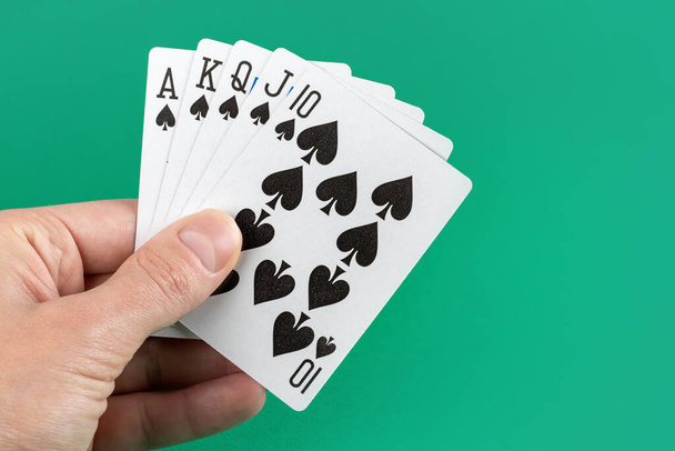 Hrací karty v ruce na zeleném pozadí. - Fotografie, Obrázek