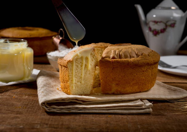 Köy ahşabında dilimsiz mısır keki ve mısırlı kumaş, tabakta dilimler ve arka planda pasta.. - Fotoğraf, Görsel