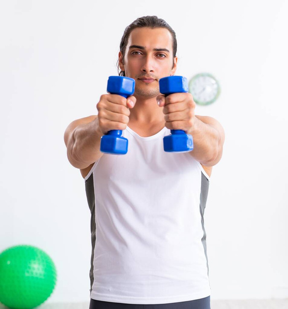 Young handsome man doing sport exercises indoors - Photo, image