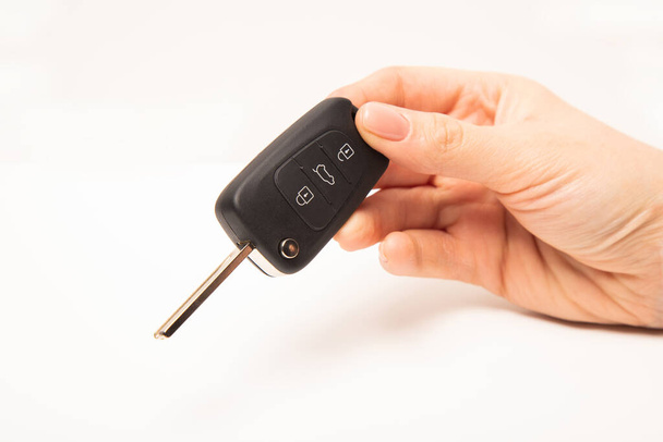 Car key in hand isolated on white background - Fotoğraf, Görsel