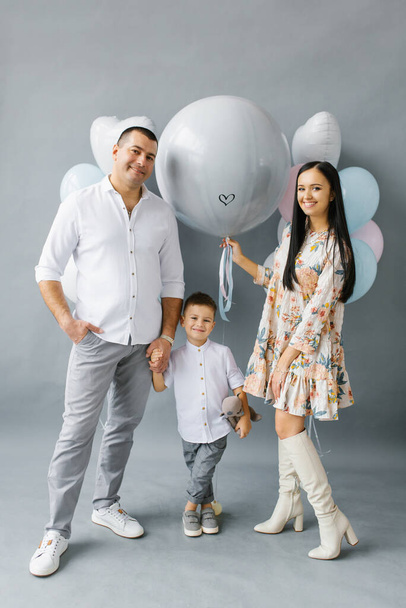 The expectant mother holds a ball in her hands, a boy or a girl. A pregnant woman's gender party. Happy family with a baby waiting for a second baby - Photo, Image