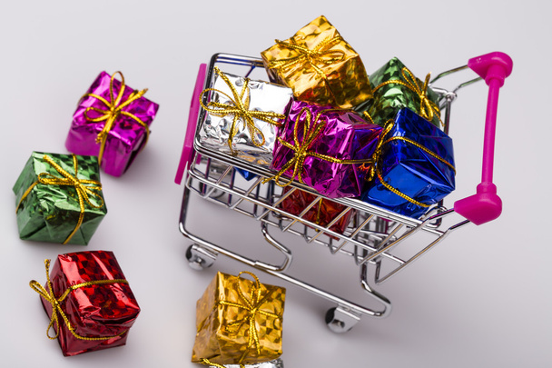 Christmas gifts in shopping trolley, isolated on white - Photo, Image