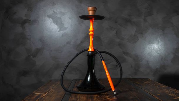 Modern orange hookah on a gray concrete abstract background. - Photo, Image