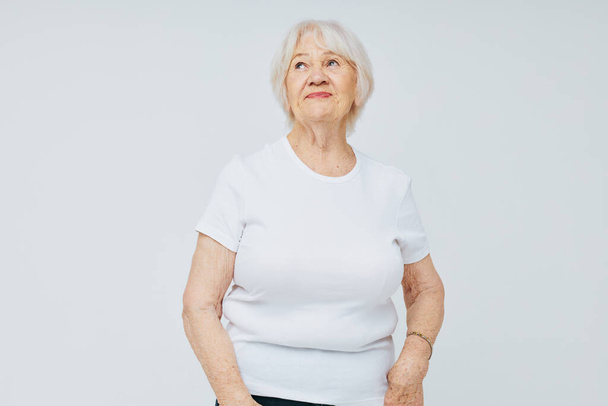Portrait of an old friendly woman health lifestyle light background - 写真・画像