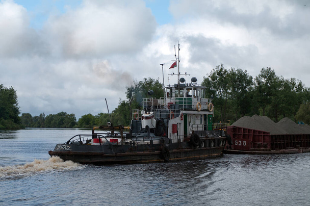 Tirón empujador "BT-0702" con barcaza "R-0538" en la confluencia de los ríos Pripyat y Pina, Pinsk, región de Brest, Bielorrusia, 15 de junio de 2014 - Foto, Imagen
