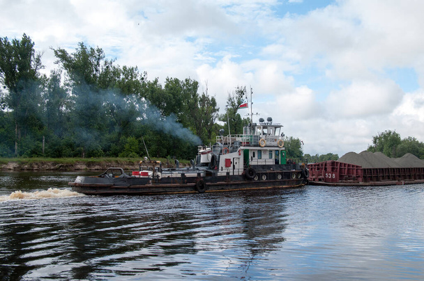 Holownik "BT-0702" z barką "R-0538" na zbiegu rzek Prypeć i Pina, Pińsk, obwód brzeski, Białoruś, 15 czerwca 2014 r. - Zdjęcie, obraz