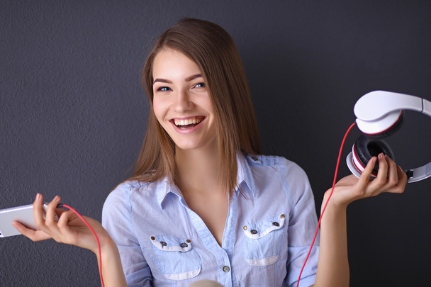 Smiling girl with headphones isolated on grey background - Photo, image