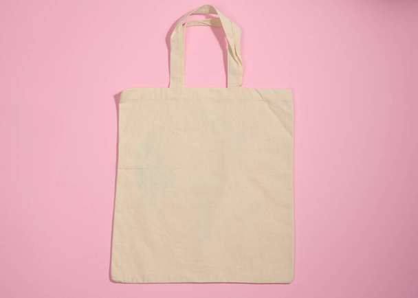 bolsa de lona beige ecológica de lino vacía para marcar sobre un fondo rosa. Bolsa reutilizable transparente para comestibles, maqueta. Puesta plana - Foto, Imagen