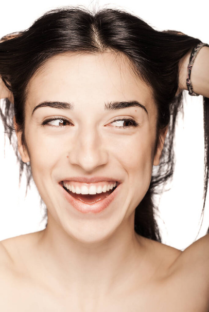 studio portrait of a beautiful brunette girl smiling against white backgroung. - Фото, изображение