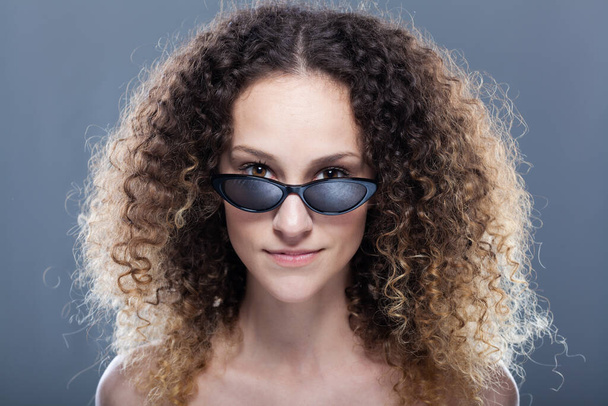 Beautiful girl with long curly hair fashion portrait wearing sunglasses - Valokuva, kuva
