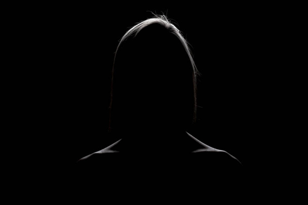 silhouette contour of a beautiful blond girl. Side lit studio portrait on dark background. - Zdjęcie, obraz