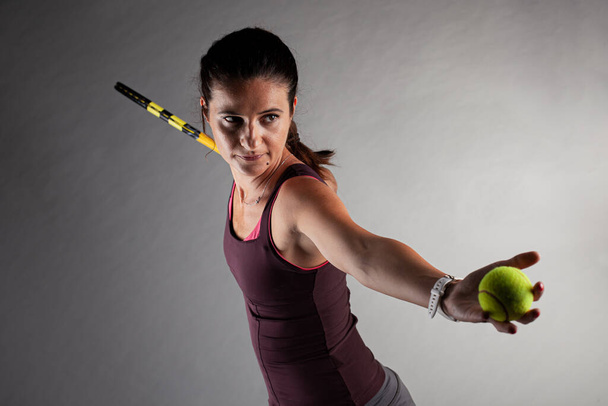 Professional female tennis player. Girl swinging racket preparing to serve - Foto, immagini