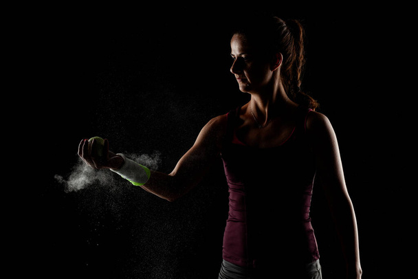 Tennis player girl with magnesium powder on her hands, grabbing a ball with dust visible. - Fotografie, Obrázek