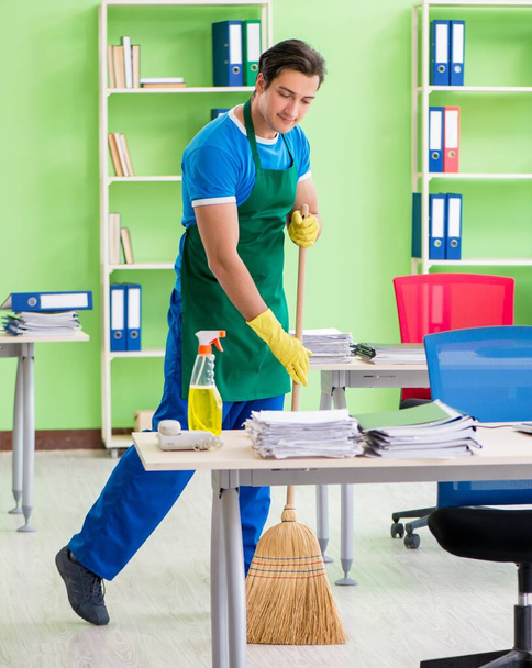 Young male handsome professional cleaner cleaning floor with bro - Photo, Image
