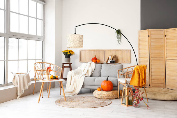 Інтер'єр сучасної вітальні зі зручним диваном, лампою та кріслами
 - Фото, зображення