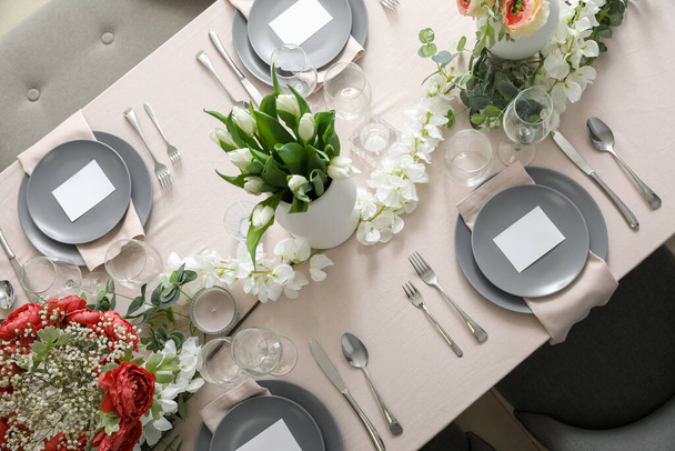 Stijlvolle tafelopstelling met tulpenbloemen en blanco kaarten - Foto, afbeelding