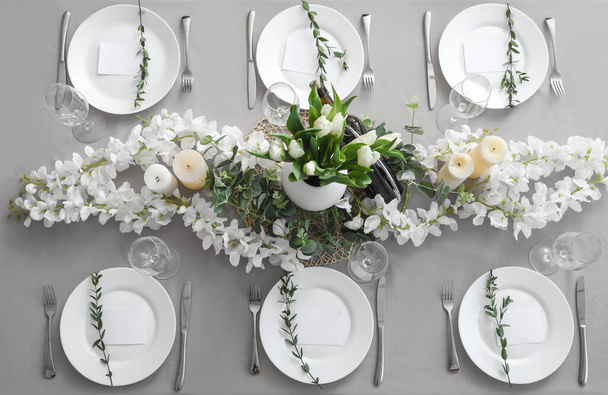 Tavolo da pranzo con bella cornice, fiori e carte bianche - Foto, immagini