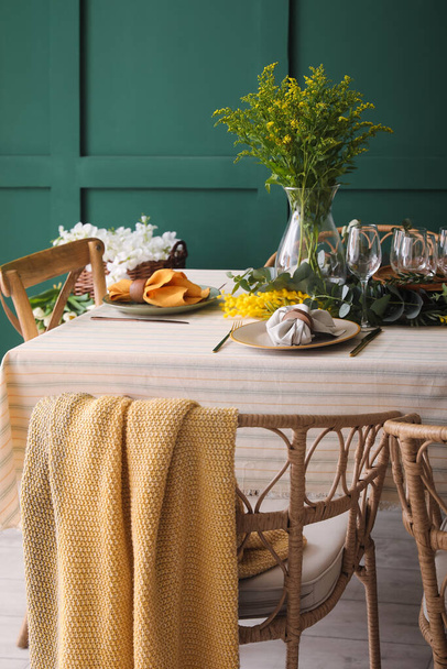 Dining table with beautiful setting near green wall - Fotoğraf, Görsel
