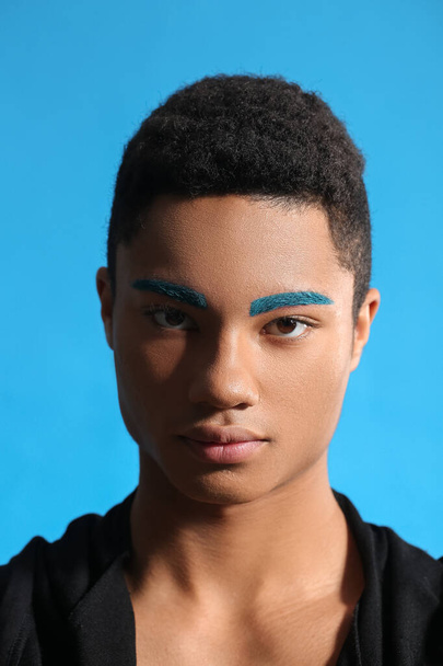 Fashionable young guy with unusual eyebrows on color background - Фото, изображение