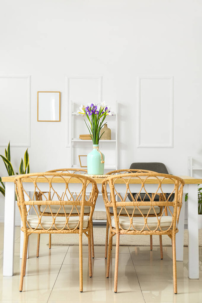 Vaas met mooie irissen op eettafel in de kamer - Foto, afbeelding