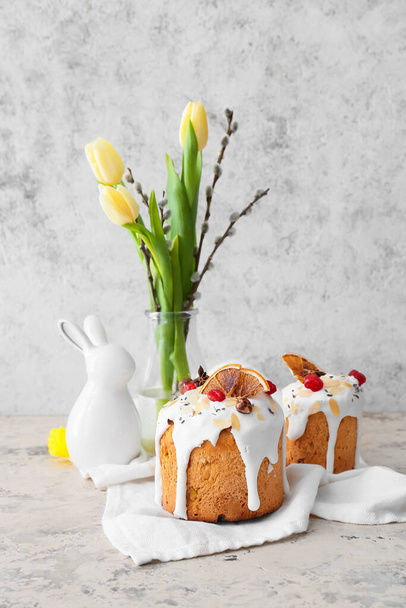 Delicious Easter cakes and pussy willow branches with tulip flowers on light background - Fotó, kép