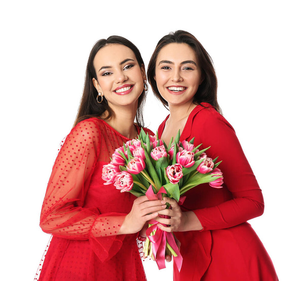 Mooie jonge vrouwen met bloemen op witte achtergrond. Internationale Vrouwendag viering - Foto, afbeelding