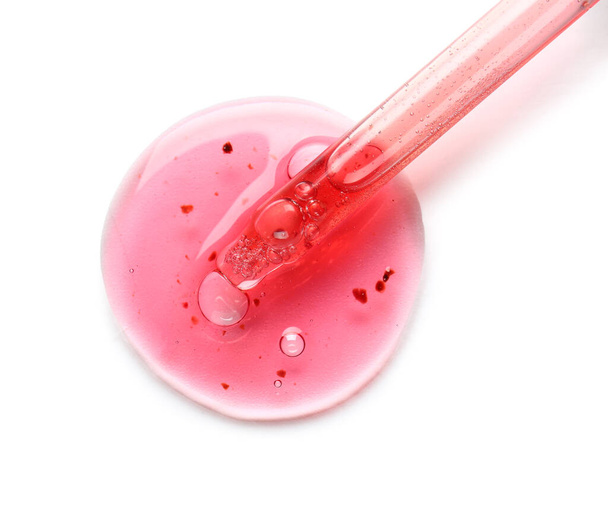 Compte-gouttes en verre et échantillon de sérum cosmétique sur fond blanc - Photo, image